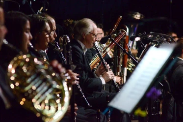 Sinfonieorchester Aachen 3 (c) Sandra Borchers.jpg Nahaufnahme von Musikern mit Blasinstrumenten des Aachener Sinfonieorchesters, die während des Spielens auf ihre Noten schauen.