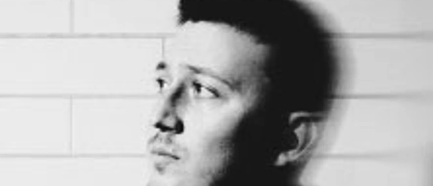 Porträt eines Mannes vor heller Wand mit Schrift Zak Abel On Tour oben