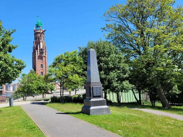 Obelisk 20220603_141407 (c) Tanja Mehl_Erlebnis Bremerhaven_WEB.jpg Obelisk im Schleusengarten mit dem Simon-Loschen-Leuchtturm im Hintergrund