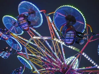 Twister Vlotho Brückenmarkt Das Fahrgeschäft Twister im dunkeln ist beleuchtet und Gäste sitzen in den Gondeln