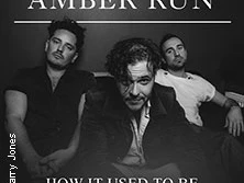 Drei Männer sitzen entspannt vor dunklem Hintergrund mit Schriftzug Amber Run Acoustic Tour