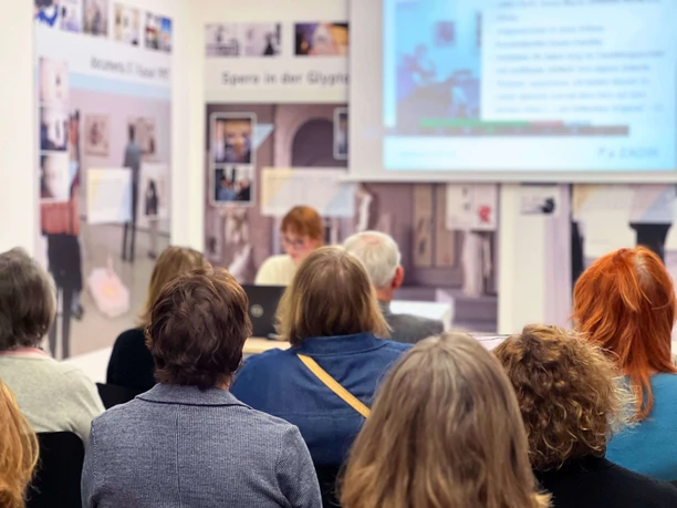 ZADIK Audience sits in a lecture room and follows a presentation in front of blackboards