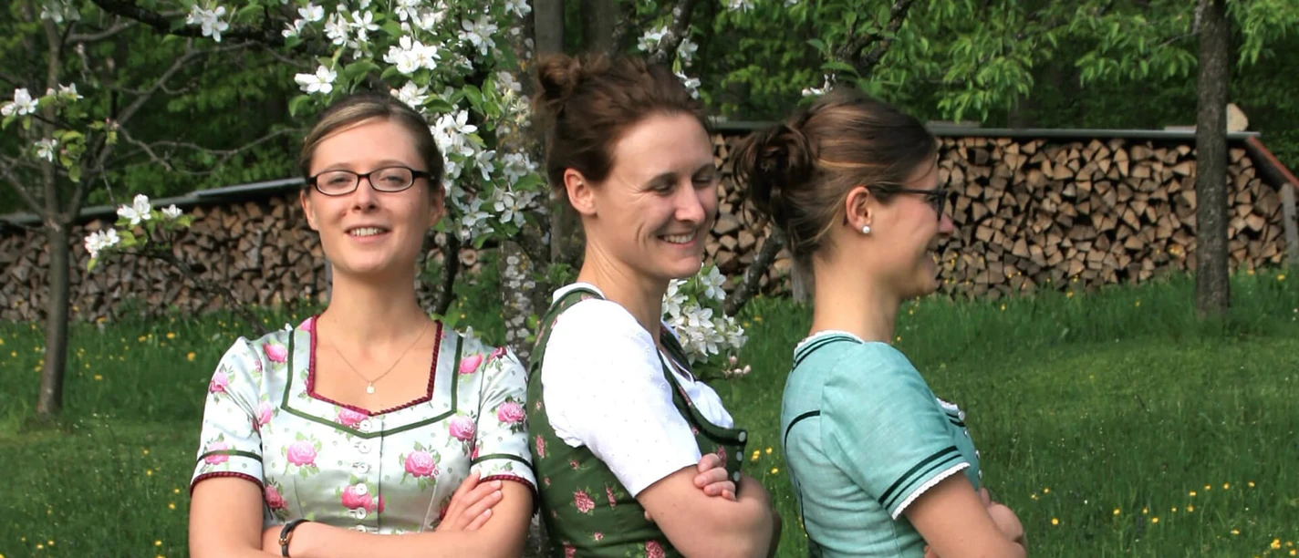 Hinterberger-Soatnmusi.jpg Drei Frauen im Dirndl vor blühenden Obstbäumen