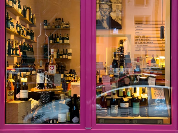 wine&glory Kiosque & ice cream parlor Pink-framed shop window with densely arranged wine bottles and shelves in the interior