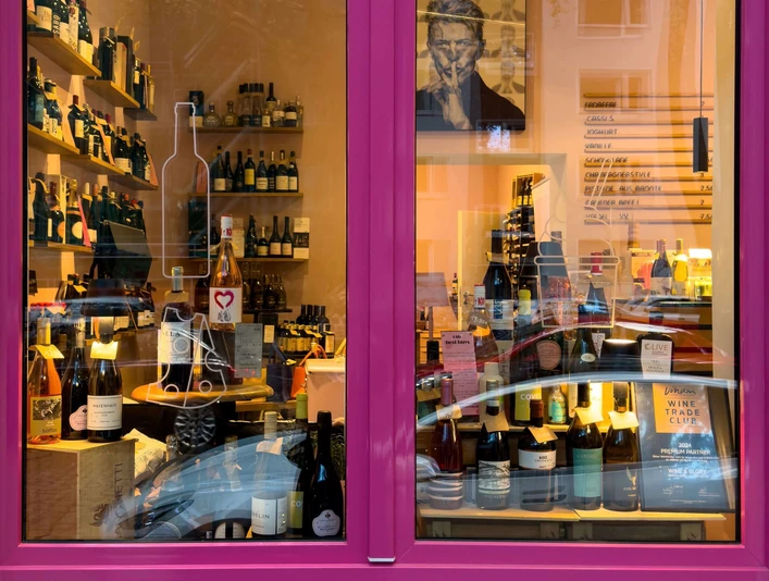 wine&glory Kiosque & ice cream parlor Pink-framed shop window with densely arranged wine bottles and shelves in the interior