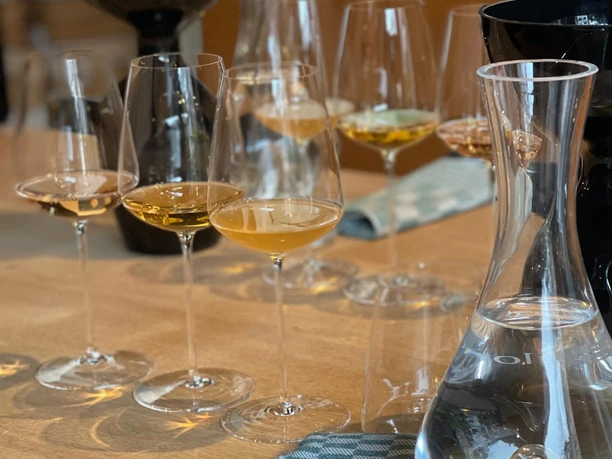 wine&glory Kiosque & Eisdiele Mehrere gefüllte Weingläser und Karaffen stehen auf einem Holztisch mit Tuch.