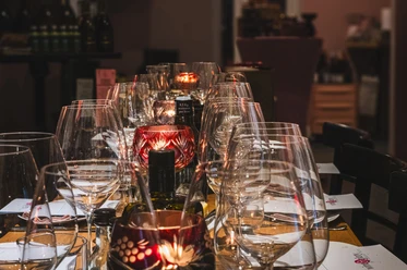 Easy tasting at the wine&glory Kiosque Table with many wine glasses, red lanterns and bottles in warm light.