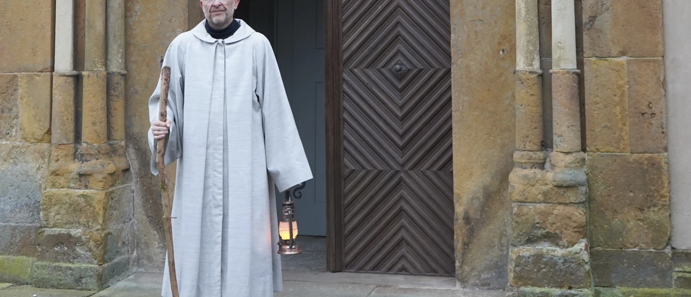 Gästeführer Jürgen Steinbeck als Bruder Matthias vor der Abteikirche in Marienfeld