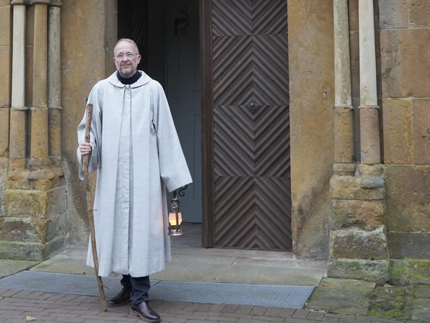 Gästeführer Jürgen Steinbeck als Bruder Matthias vor der Abteikirche in Marienfeld