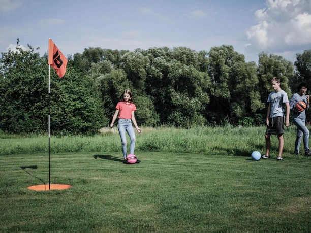 Red Lama Freizeit Resort - Fußballgolf Jugendliche spielen Fußballgolf auf einer Wiese.