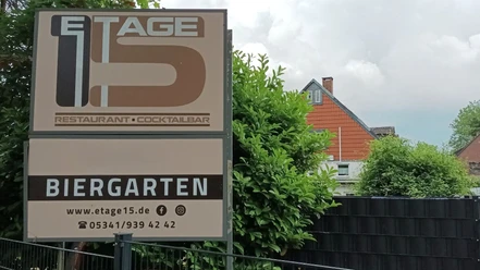 Etage15_Salzgitter_HD_16zu9.jpg Außenschild von Etage 15 mit Restaurant- und Biergartenhinweis vor Wohnhäusern