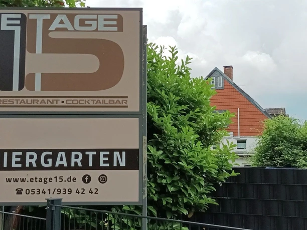Etage15_Salzgitter_HD_16zu9.jpg Außenschild von Etage 15 mit Restaurant- und Biergartenhinweis vor Wohnhäusern