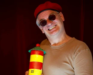 Ausbilder Schmidt in Pilsum Comedian Ausbilder Schmidt mit roter Mütze und Leuchtturm-Requisite auf der Bühne
