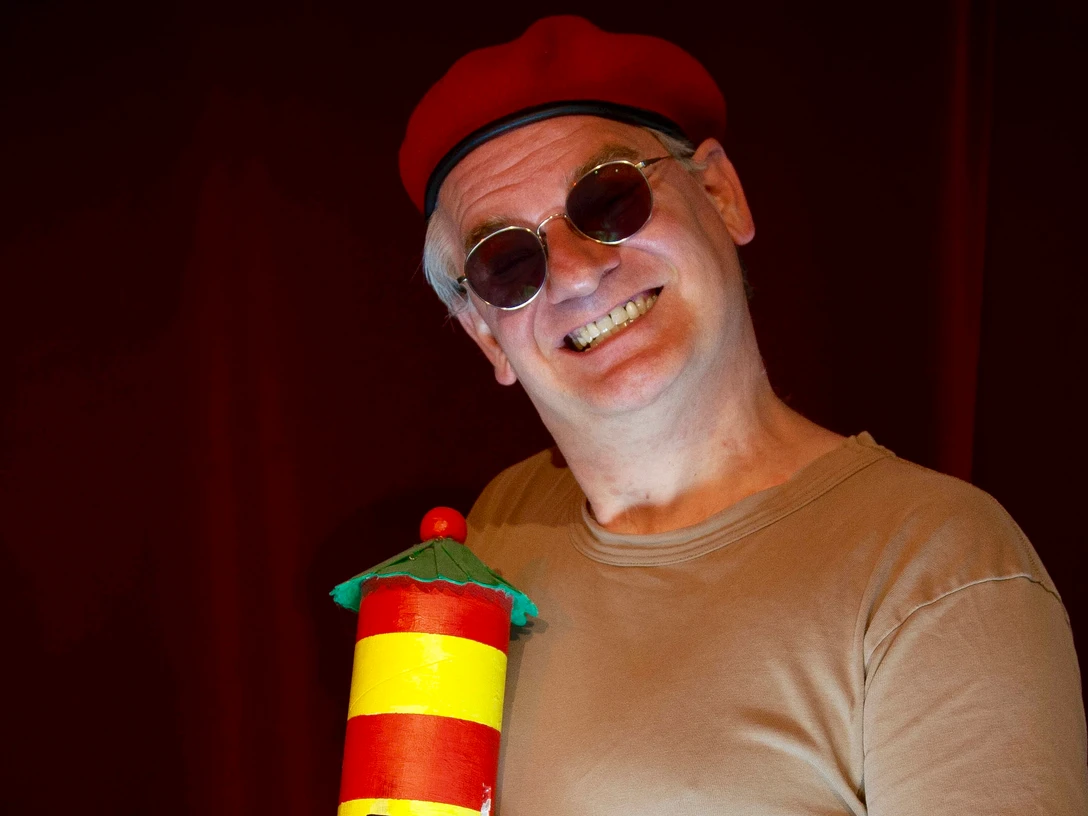 Ausbilder Schmidt in Pilsum Comedian Ausbilder Schmidt mit roter Mütze und Leuchtturm-Requisite auf der Bühne