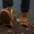 Wanderer Tiefwinkelaufnahme von Wanderstiefeln auf Fels beim Biwakieren in der Natur