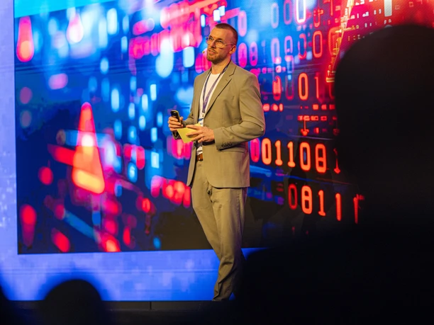 Speaker in front of a digital presentation wall at a conference in Leipzig | Leipzig Convention Bureau Speaker standing in front of a digital presentation wall at a conference – presented by Leipzig Convention Bureau