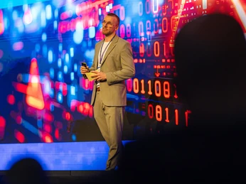 Vortragssituation bei einer Tagung oder Konferenz | Leipzig Convention Bureau Person steht vor einer digitalen Leinwand bei einer Tagung oder Konferenz – präsentiert vom Leipzig Convention Bureau