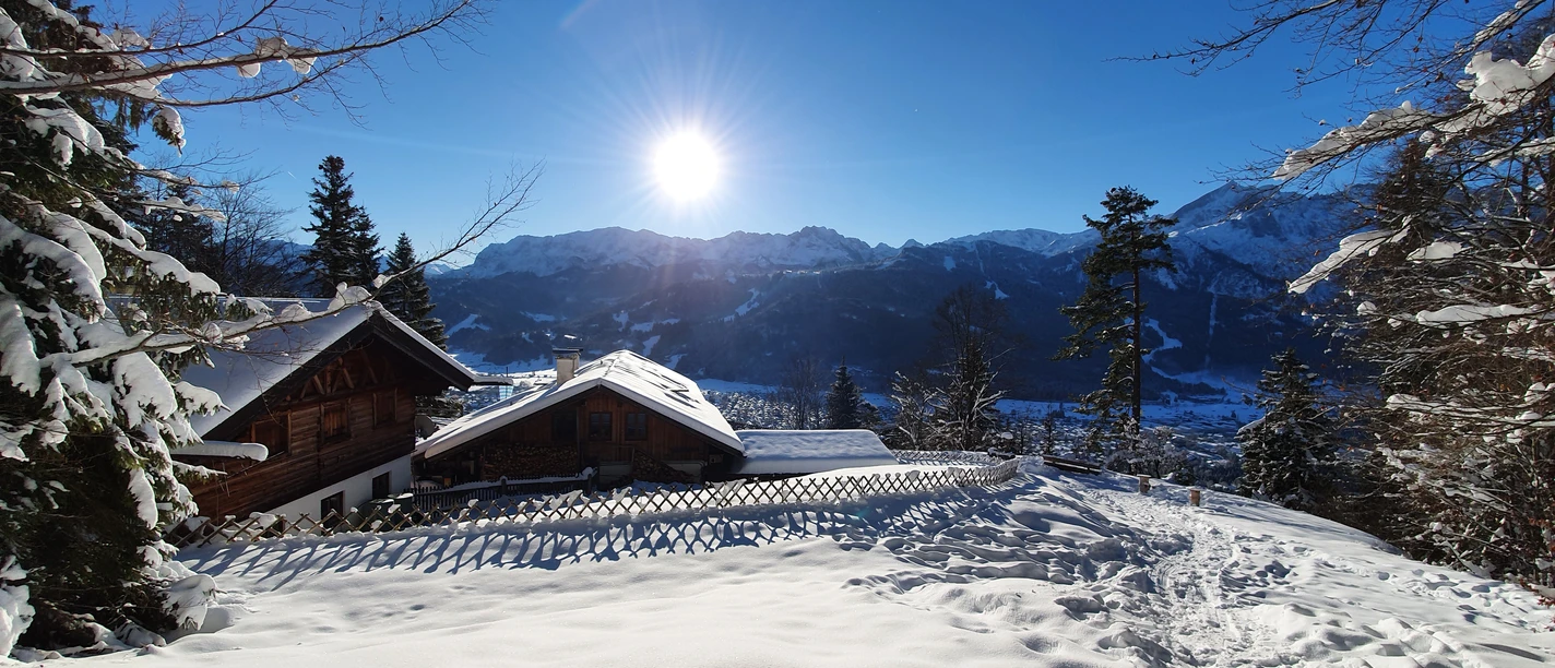 St. Martins Hütte im Winter Verschneite Berghütte mit sonniger Winterlandschaft und Blick auf umliegende Gipfel