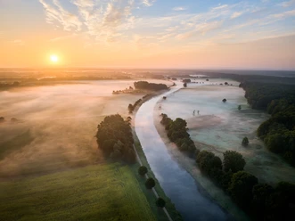 Luftaufnahme des Elbe-Lübeck-Kanals bei Sonnenaufgang und Nebel.