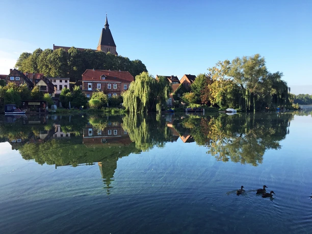 Stadtsee Mölln Ein Blick über den Stadtsee auf die Mölln. Die Stadt und der Kirchturm spiegeln sich im Wasser.