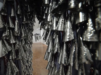 Installation view HERE AND NOW at the Museum Ludwig. De/Collecting Memories Museum Ludwig, Cologne 2026 Shimmering metallic installation forms a passageway to an object in the exhibition space