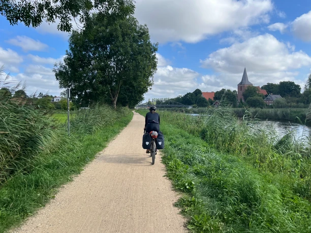 Radfahrerin auf der Alten Salzstraße bei Berkenthin. Eine Radfahrerin mit Gepäcktaschen auf dem Radfernweg Alte Salzstraße bei Berkenthin.