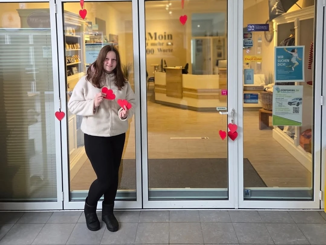 Valentinstag©M.Sahm.jpg Tina, Angestellte des Tourismus-Service Friedrichskoog präsentiert vor dem Office die Herzen der Valentinsaktion, die im Trischendiek Park versteckt werden