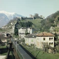 Bellinzona: hinten die Montebello-Burg, vorne der Personenzug | Bellinzone: à l’arrière-plan, le château de Montebello; au premier, le train de voyageurs | Bellinzona: dietro il Castello di Montebello, davanti il treno passeggeri, ≈ 1975.