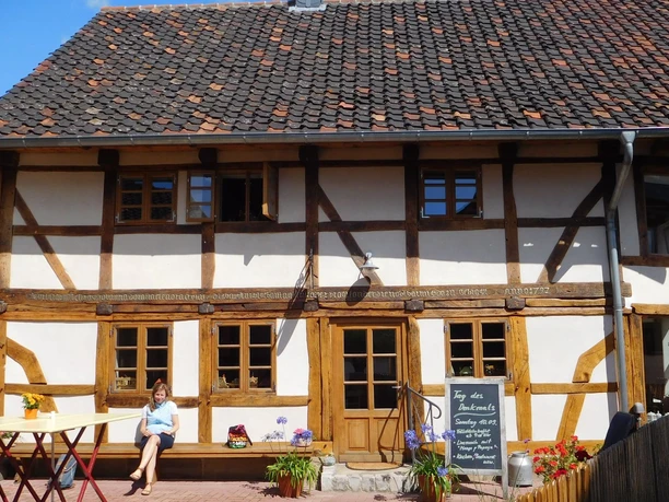 Dorfcafe Alt Bleckenstedt (12)_HD_16zu9.JPG Historisches Fachwerkhaus von 1727 mit Cafébetrieb, Holzbalken und Sitzgelegenheiten im Außenbereich