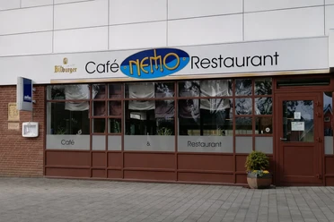 Restaurant Nemo Otterndorf Außenansicht des Café & Restaurants Nemo mit Fensterfront und Eingangstür.