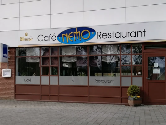 Restaurant Nemo Otterndorf Außenansicht des Café & Restaurants Nemo mit Fensterfront und Eingangstür.