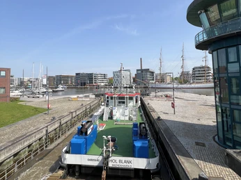 IMG_7873 (c) Mailin Knoke_Erlebnis Bremerhaven_WEB.jpg Arbeitsschiff in der Schleuse Neuer Hafen Bremerhaven mit dem Schulschiff Deutschland im Hintergrund