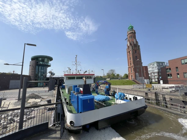IMG_7878 (c) Mailin Knoke_Erlebnis Bremerhaven_WEB.jpg Arbeitsschiff in der Schleuse Neuer Hafen mit dem Simon Loschen-Leuchtturm im Hintergrund