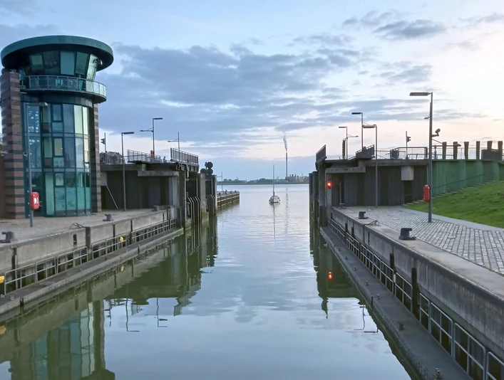 210729 (c) Andrea Schuchardt_Erlebnis Bremerhaven_WEB.jpg Blick durch die offene Schleuse Neuer Hafen hinaus auf die Weser, von wo ein Segelboot einläuft