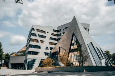 Leuphana Zentralgebäude Asymmetrisches Leuphana Zentralgebäude "Libeskindbau" mit silberner Fassade und schrägen Fenstern.