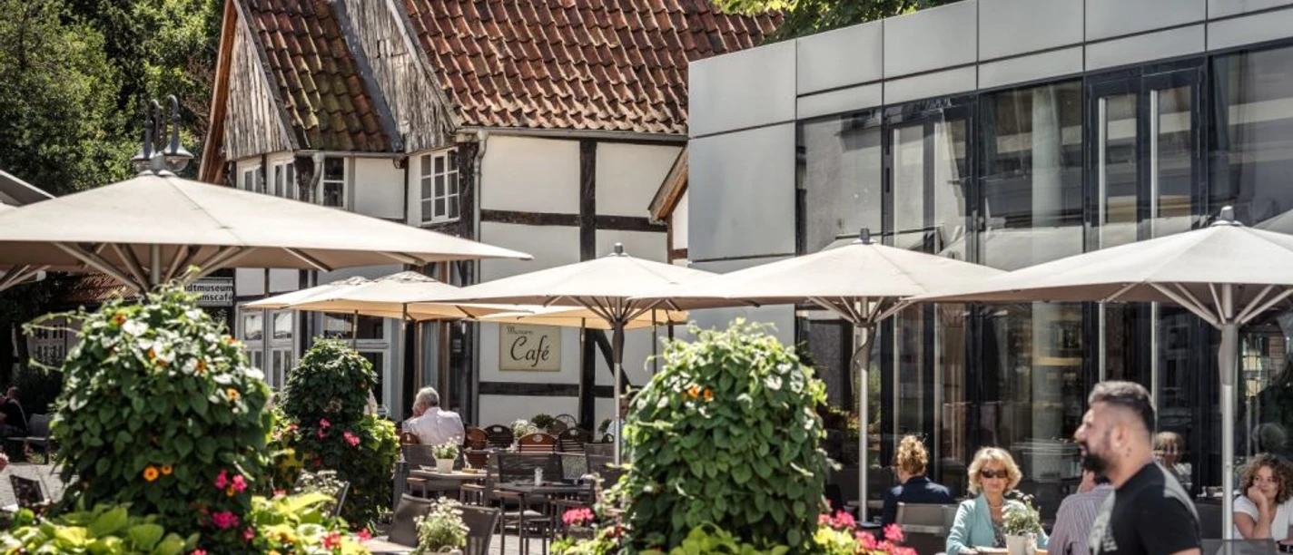 Mit westfälischem Charme, Erinnerungen und Genuss Außengastronomie am Kolbeplatz mit Fachwerkhäusern und Caféterrasse in Gütersloh