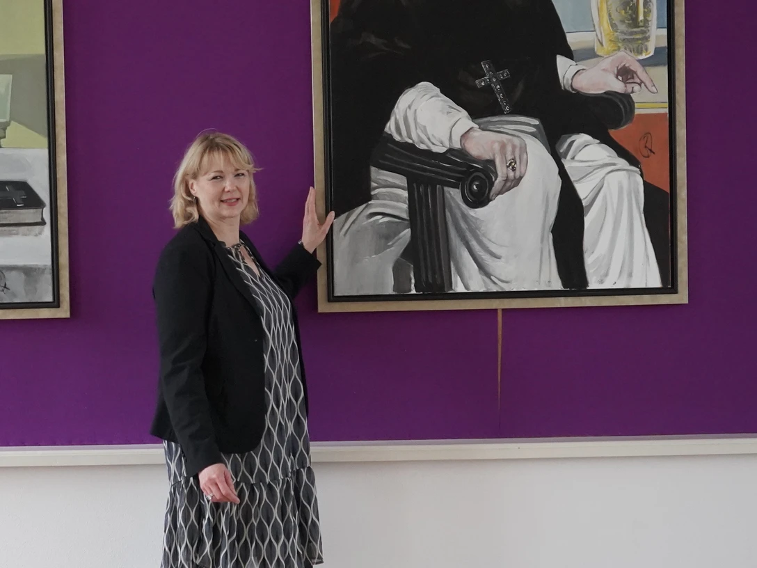 Marienfeld-Bärbel-Tophinke-mit Bildergalerie-der-Äbte-Teutoburger-Wald-Stadt-Harsewinkel-U.-Mussmann.jpg Die Gästeführerin Bärbel Tophinke steht vor der Bildergalerie der Äbte.