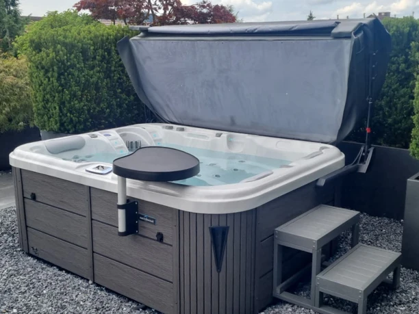 Whirlpool draussen umgeben von einer grünen Hecke