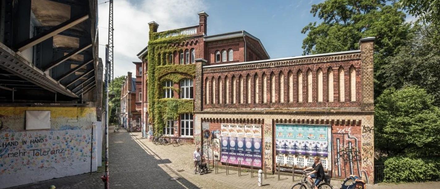 Weberei Backsteingebäude der Weberei in Gütersloh mit Efeu, Radfahrer mit Anhänger