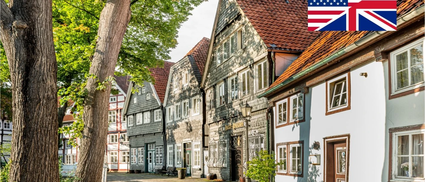 Gütersloh Unplugged Historische Fachwerkhäuser in Gütersloh, ruhige Gasse mit Bäumen und Flaggenhinweis Englisch
