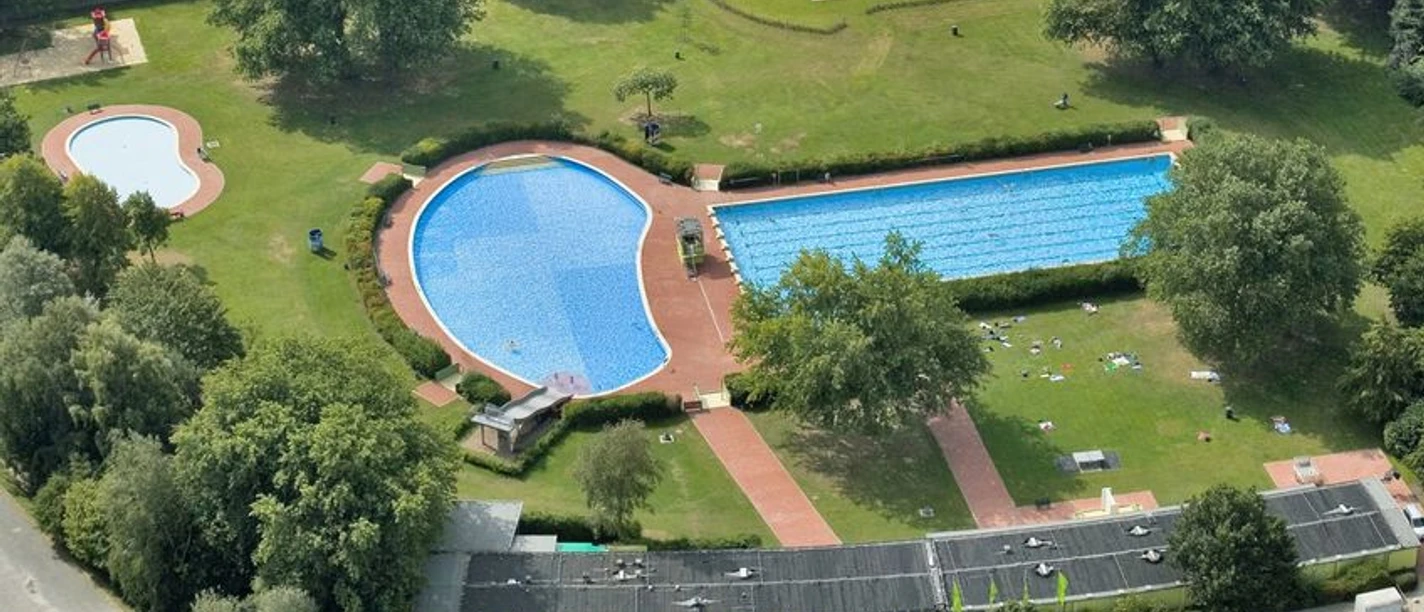 Luftbild Freibad Grünhöfe.jpg Luftbildaufnahme des Freibads mit Schwimmer-, Nichtschwimmer- und Planschbecken sowie Liegewiese.