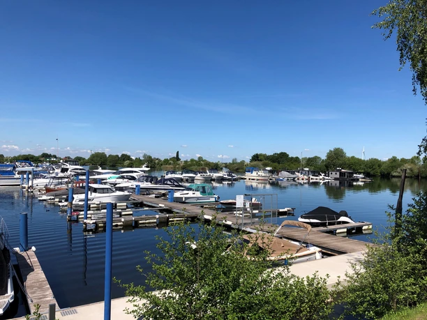 Wieltsee Ein sonniger Tag am Yachthafen mit zahlreichen angelegten Booten auf einem ruhigen See.