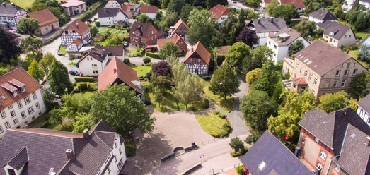 Luftaufnahme des Marktplatzes Hohenhausen mit Fachwerkhäusern, Bäumen und Straßen