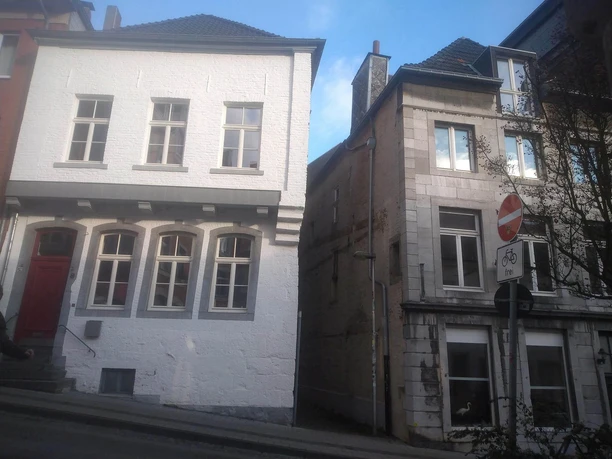 Historische Häuserfassaden liegen an einer abgeschrägten Straße.