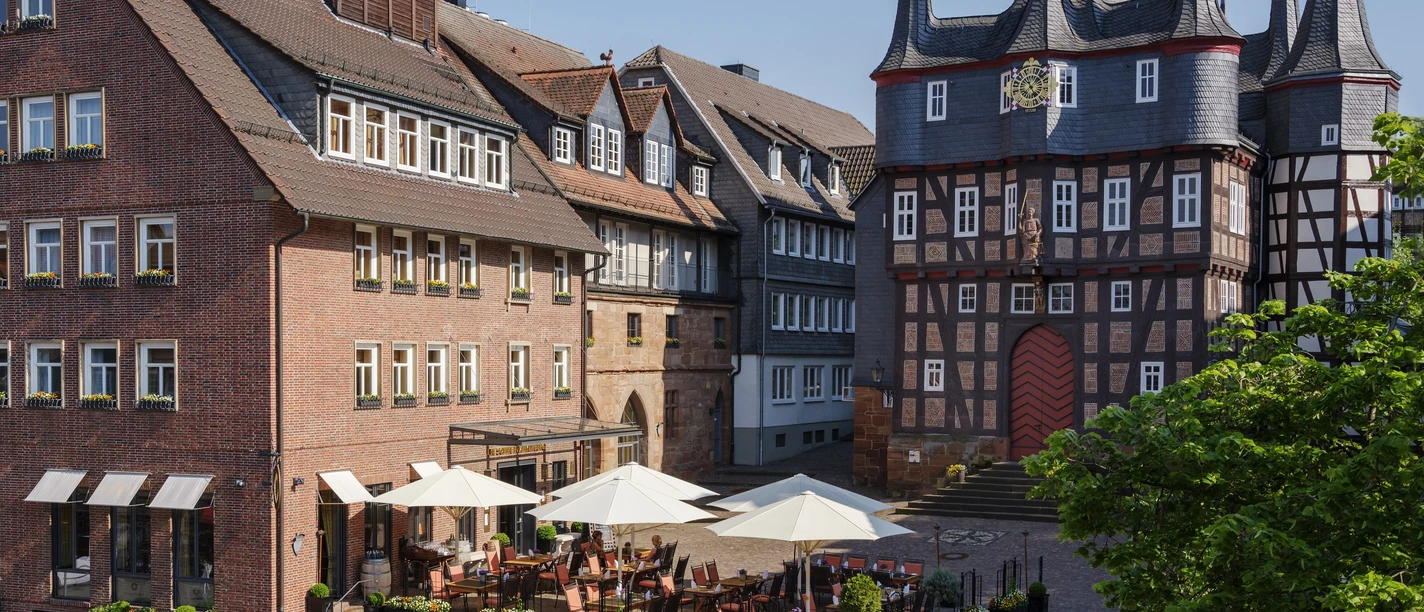 Sie sehen das Hauptgebäude des Hotels "Die Sonne Frankenberg" mit seiner Terrassenanlage, neben den historischen Rathaus der Stadt Frankenberg (Eder).