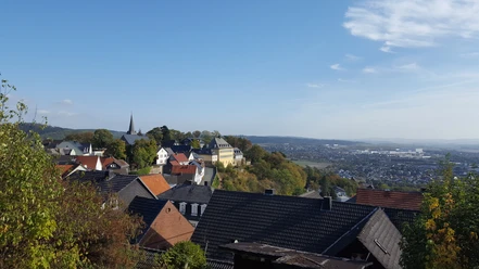 Blick auf die Neuburg in Battenberg (Eder) Sie sehen eine weitläufige Aussicht über die Stadt Battenberg (Eder) mit ihren vielen Wohnhäusern und die Neuburg im Hintergrund.
