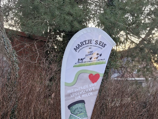Martje’s Eis Weißes Werbebanner mit Logo und grünen Eisbechern von Martje’s Eis im Grünen.