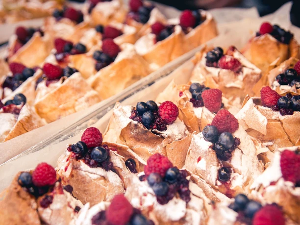 Street Food Festival in Ehrenfeld Trays of fluffy pastries filled with cream and fresh raspberries and blueberries.