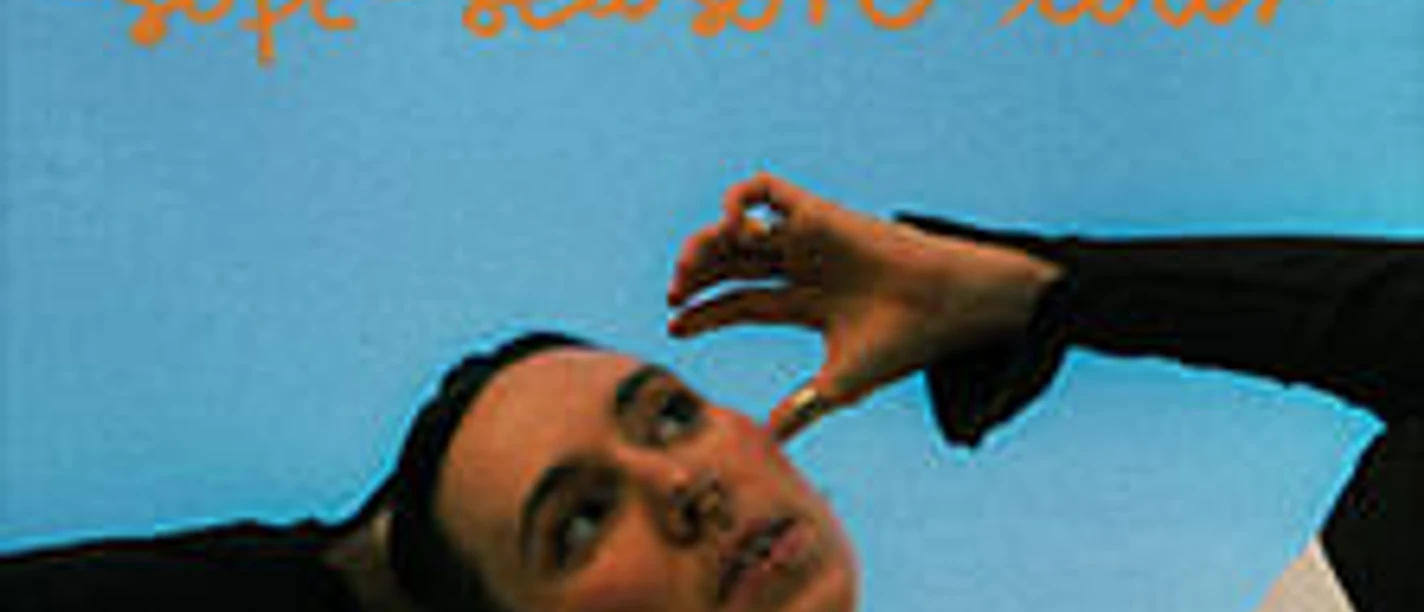 Eine Person vor blauem Hintergrund posiert unter orangefarbenem Schriftzug soft season tour