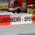 Durchs Feuer gehen - Brandschutztour mit der Feuerwehr Mettmann Absperrband "Feuerwehr - Sperrzone" vor unscharfen Einsatzfahrzeugen der Feuerwehr Mettmann.